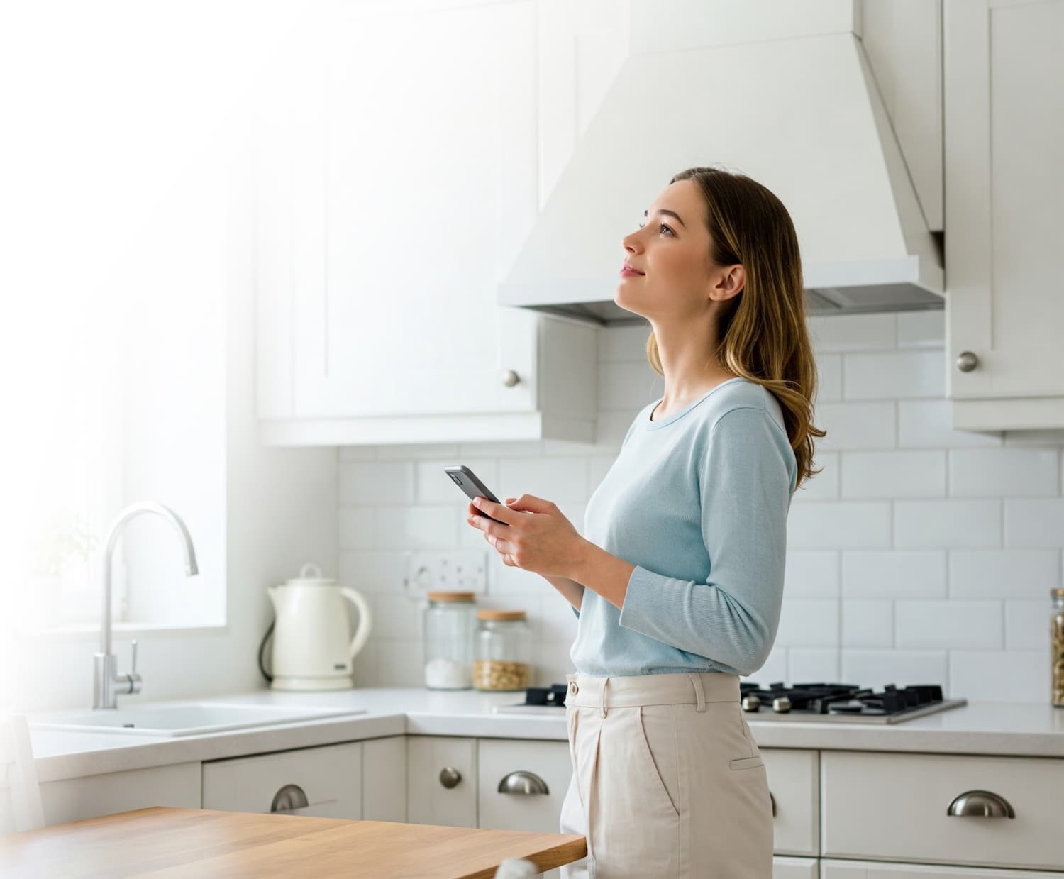 Woman using smartphone in modern kitchen